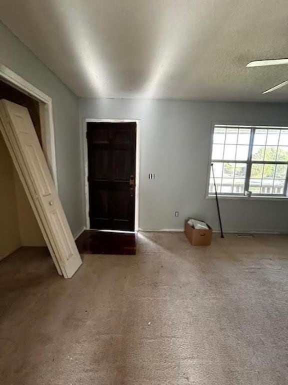 carpeted foyer with ceiling fan