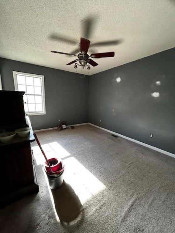 unfurnished bedroom featuring ceiling fan, a textured ceiling, and carpet flooring