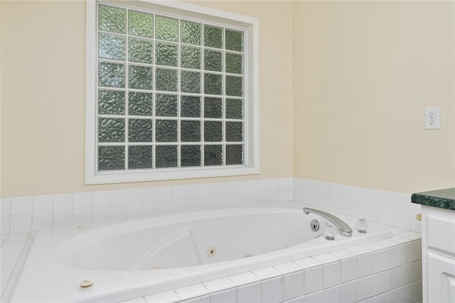 bathroom featuring vanity and a relaxing tiled tub