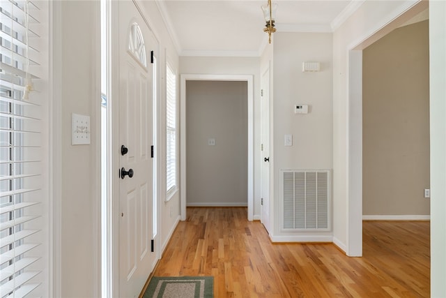 foyer entrance featuring crown molding and light hardwood / wood-style floors