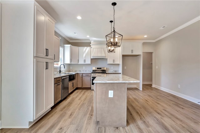 kitchen with hanging light fixtures, white cabinetry, a kitchen island, stainless steel appliances, and light wood-type flooring