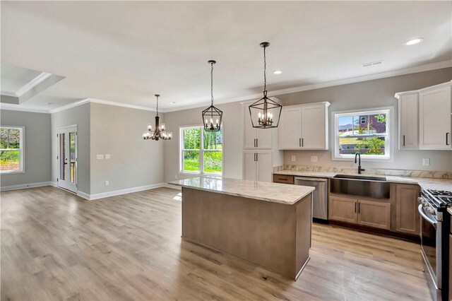 kitchen featuring white cabinetry, hanging light fixtures, a kitchen island, appliances with stainless steel finishes, and light stone countertops