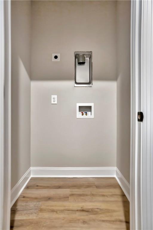 washroom with hookup for a washing machine, light hardwood / wood-style flooring, and hookup for an electric dryer