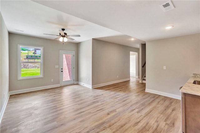 unfurnished living room featuring light hardwood / wood-style flooring and ceiling fan