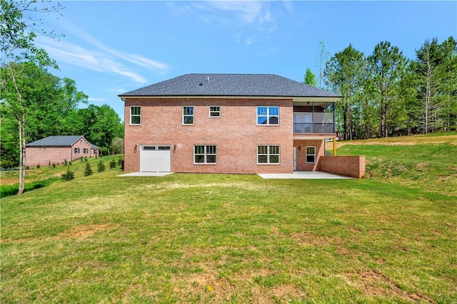 rear view of property featuring a garage, a patio, and a yard