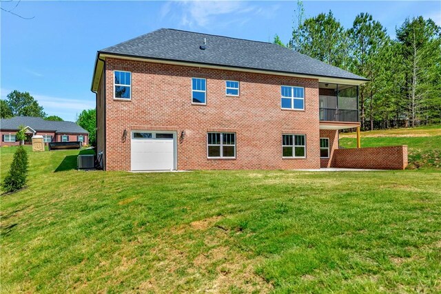 back of house featuring central AC unit, a garage, and a yard