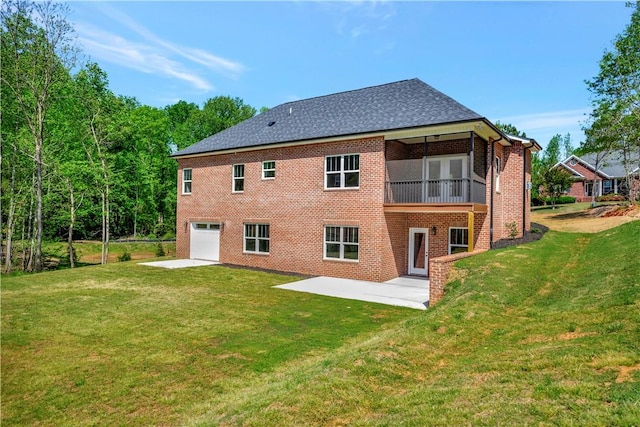 back of property with a yard, a garage, and a patio area