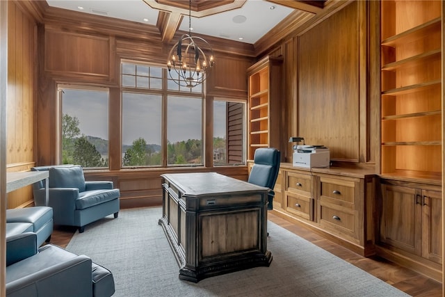 home office with built in features, an inviting chandelier, and wood walls