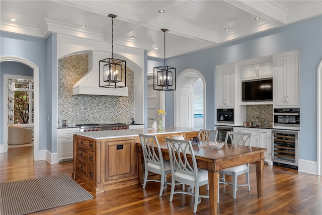 kitchen featuring wine cooler, white cabinets, decorative light fixtures, and a kitchen island