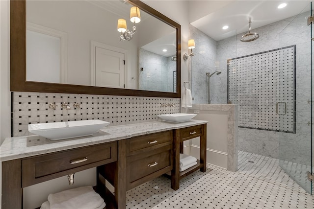 bathroom with a shower with door, vanity, and tasteful backsplash