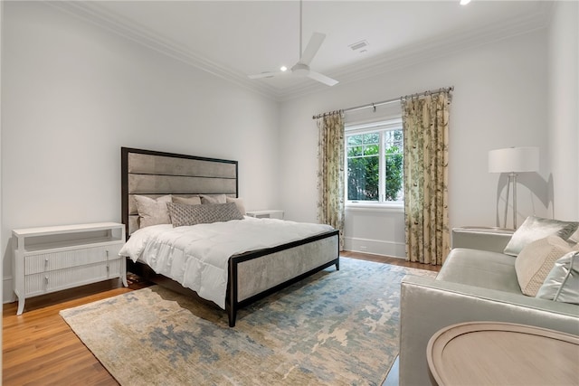 bedroom with ceiling fan, ornamental molding, and hardwood / wood-style floors