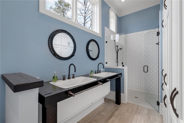 bathroom with vanity, crown molding, hardwood / wood-style flooring, and a shower with shower door