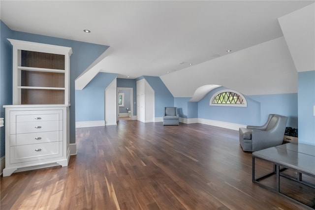 additional living space with dark wood-type flooring and vaulted ceiling