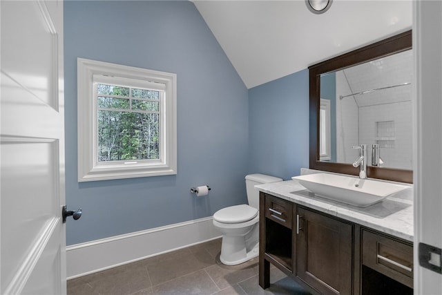 bathroom featuring toilet, vanity, and vaulted ceiling