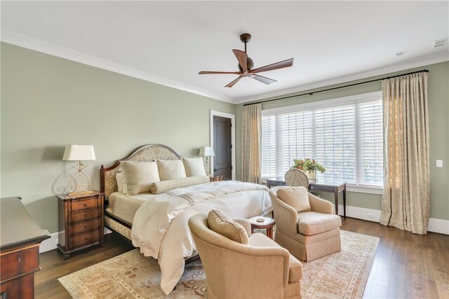 bedroom with crown molding, dark hardwood / wood-style floors, and ceiling fan