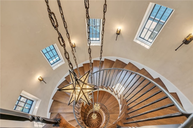 stairway with a towering ceiling and a healthy amount of sunlight