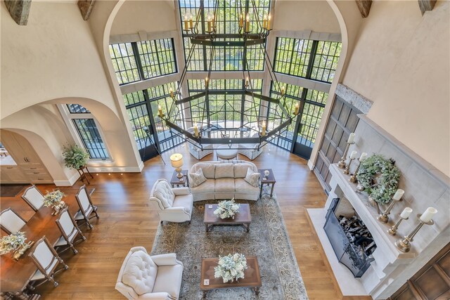 living room with wood-type flooring, a towering ceiling, and a wealth of natural light