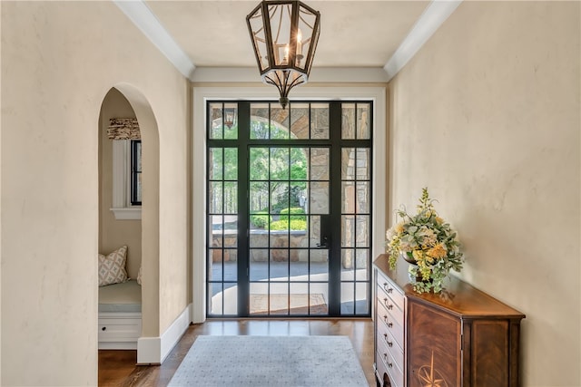 doorway to outside with a chandelier and dark wood-type flooring