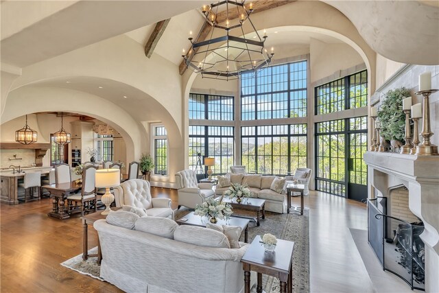 living room featuring beam ceiling, hardwood / wood-style floors, high vaulted ceiling, and a healthy amount of sunlight