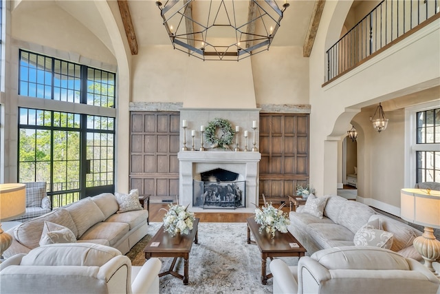 living room featuring wood-type flooring, beamed ceiling, and high vaulted ceiling