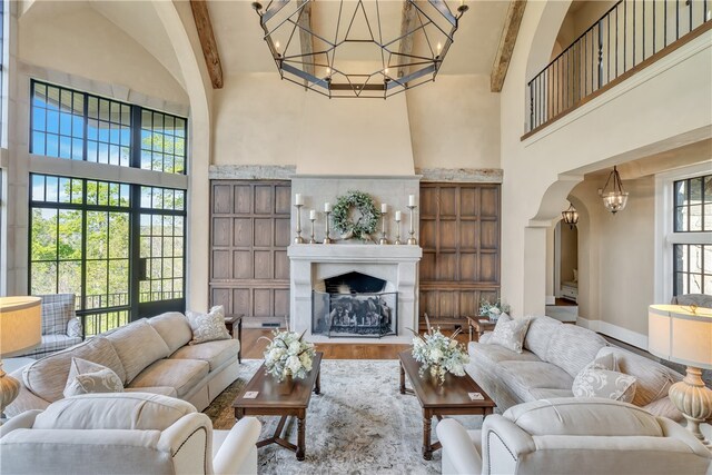 living room featuring wood-type flooring, beamed ceiling, and high vaulted ceiling