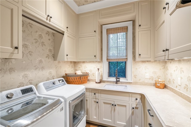 washroom featuring cabinets, sink, and washing machine and dryer