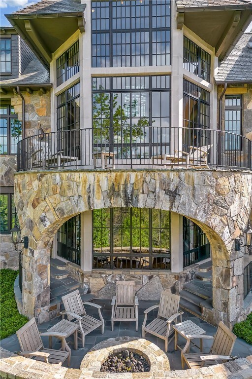 view of patio featuring a balcony and an outdoor fire pit