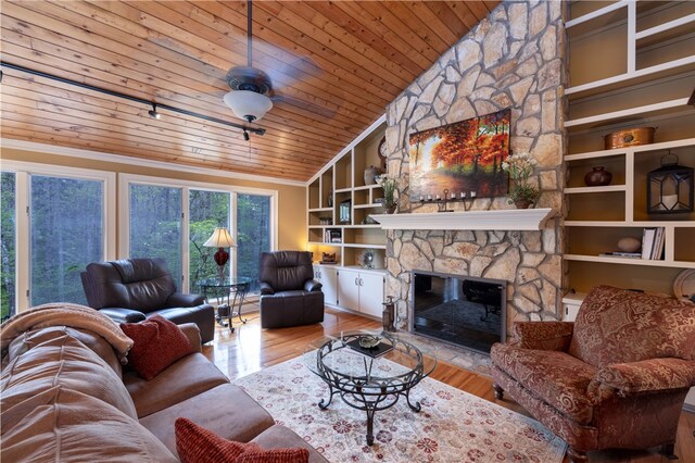 living room featuring a fireplace, lofted ceiling, built in shelves, light hardwood / wood-style floors, and wooden ceiling