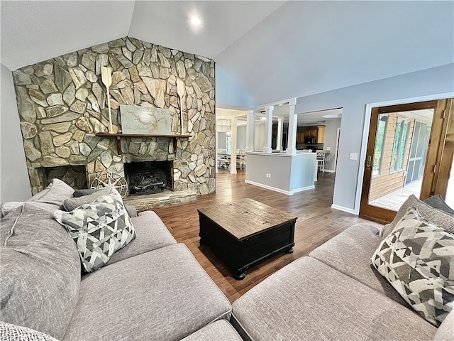 living room with lofted ceiling, decorative columns, hardwood / wood-style floors, and a fireplace