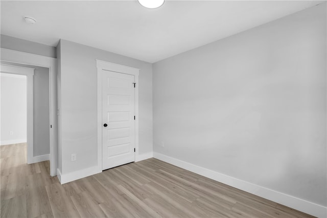 unfurnished bedroom featuring light hardwood / wood-style flooring and a closet