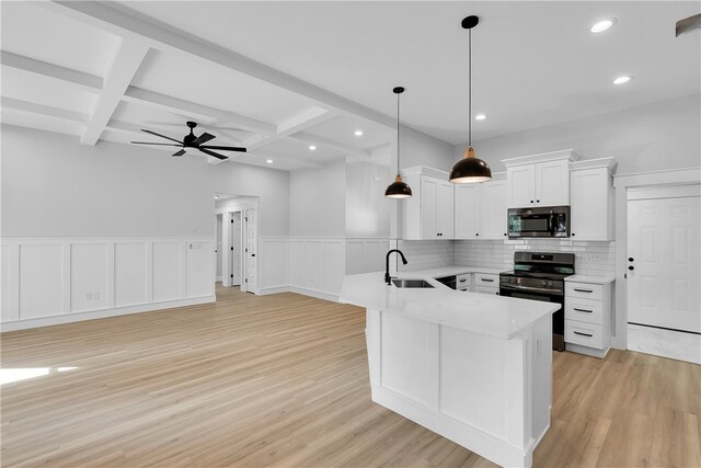 kitchen featuring white cabinets, pendant lighting, sink, appliances with stainless steel finishes, and light hardwood / wood-style floors