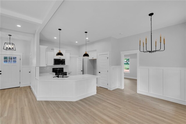 kitchen with tasteful backsplash, white cabinets, kitchen peninsula, light hardwood / wood-style flooring, and decorative light fixtures