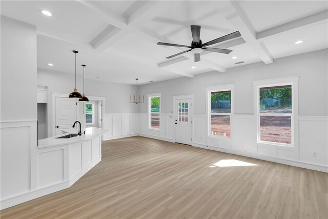 unfurnished living room featuring coffered ceiling, beamed ceiling, sink, and light hardwood / wood-style floors