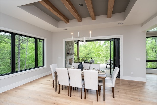 dining area featuring beamed ceiling, a chandelier, and light hardwood / wood-style floors