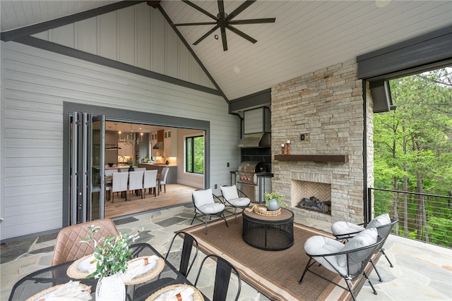 view of patio / terrace featuring area for grilling, an outdoor stone fireplace, and ceiling fan