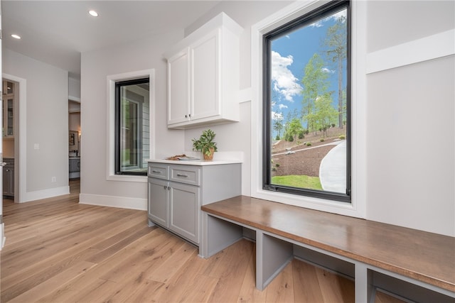 interior space featuring gray cabinets, light hardwood / wood-style floors, and white cabinetry