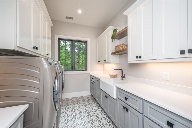 washroom featuring cabinets, separate washer and dryer, and sink