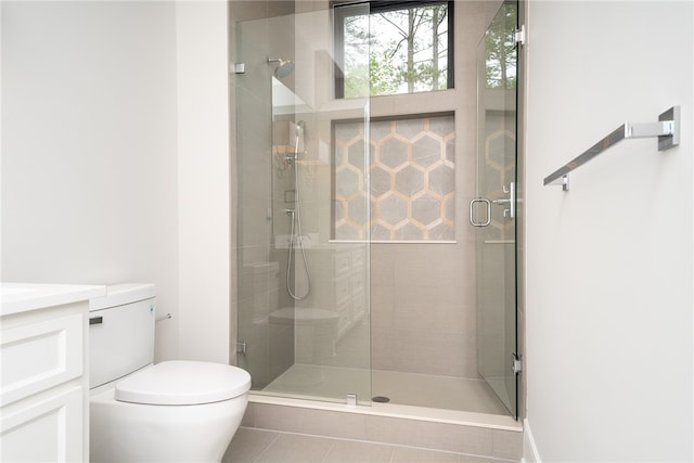 bathroom featuring vanity, toilet, tile patterned floors, and an enclosed shower