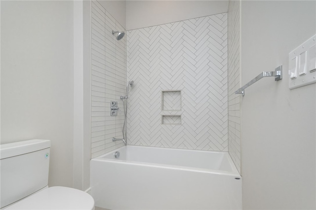 bathroom featuring tiled shower / bath combo and toilet