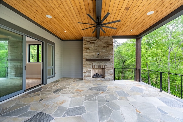 view of patio with a balcony, ceiling fan, and an outdoor stone fireplace