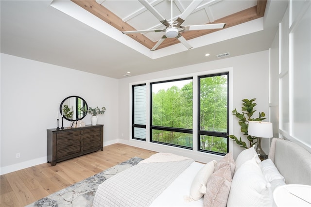 bedroom featuring ceiling fan, beamed ceiling, and light hardwood / wood-style flooring