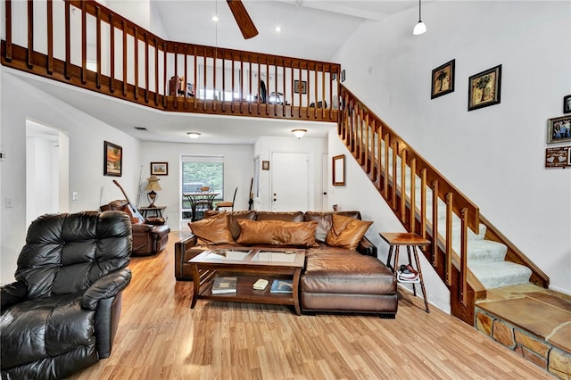 living room with beam ceiling, ceiling fan, light hardwood / wood-style flooring, and high vaulted ceiling