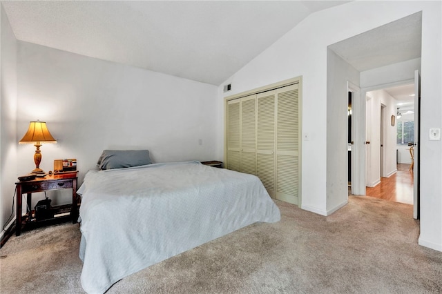 carpeted bedroom featuring a closet and lofted ceiling