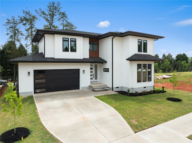 view of front of home with a garage and a front lawn