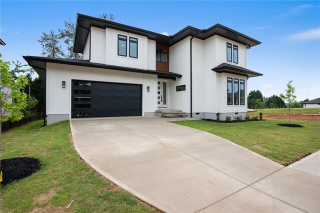 view of front of property with a garage and a front lawn