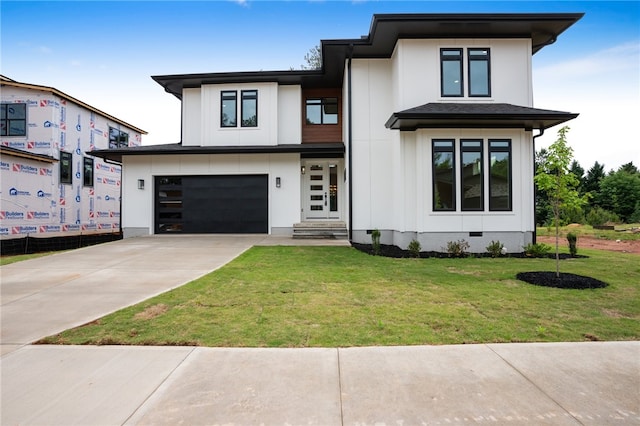 prairie-style home featuring a front lawn and a garage