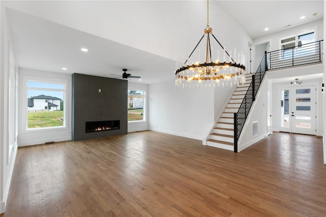 unfurnished living room featuring ceiling fan, dark hardwood / wood-style flooring, and a large fireplace