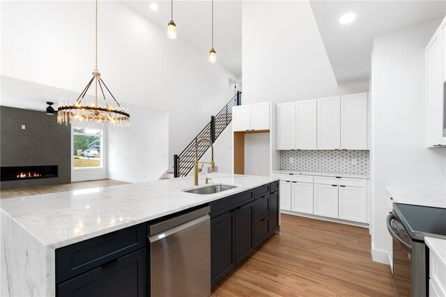 kitchen featuring pendant lighting, stainless steel appliances, and high vaulted ceiling