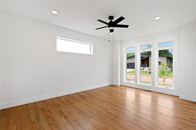 spare room with a wealth of natural light, light hardwood / wood-style floors, and ceiling fan