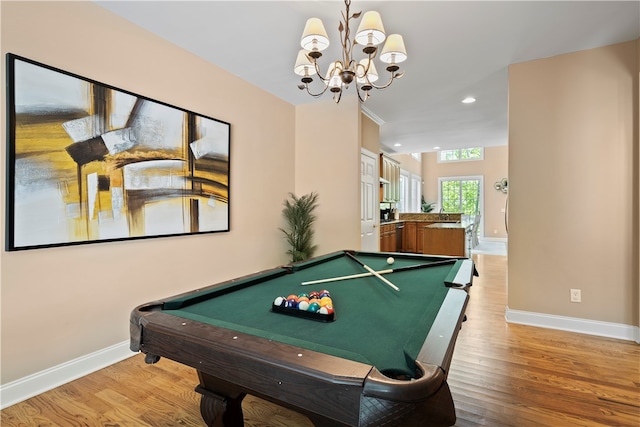 recreation room with an inviting chandelier, hardwood / wood-style flooring, and pool table